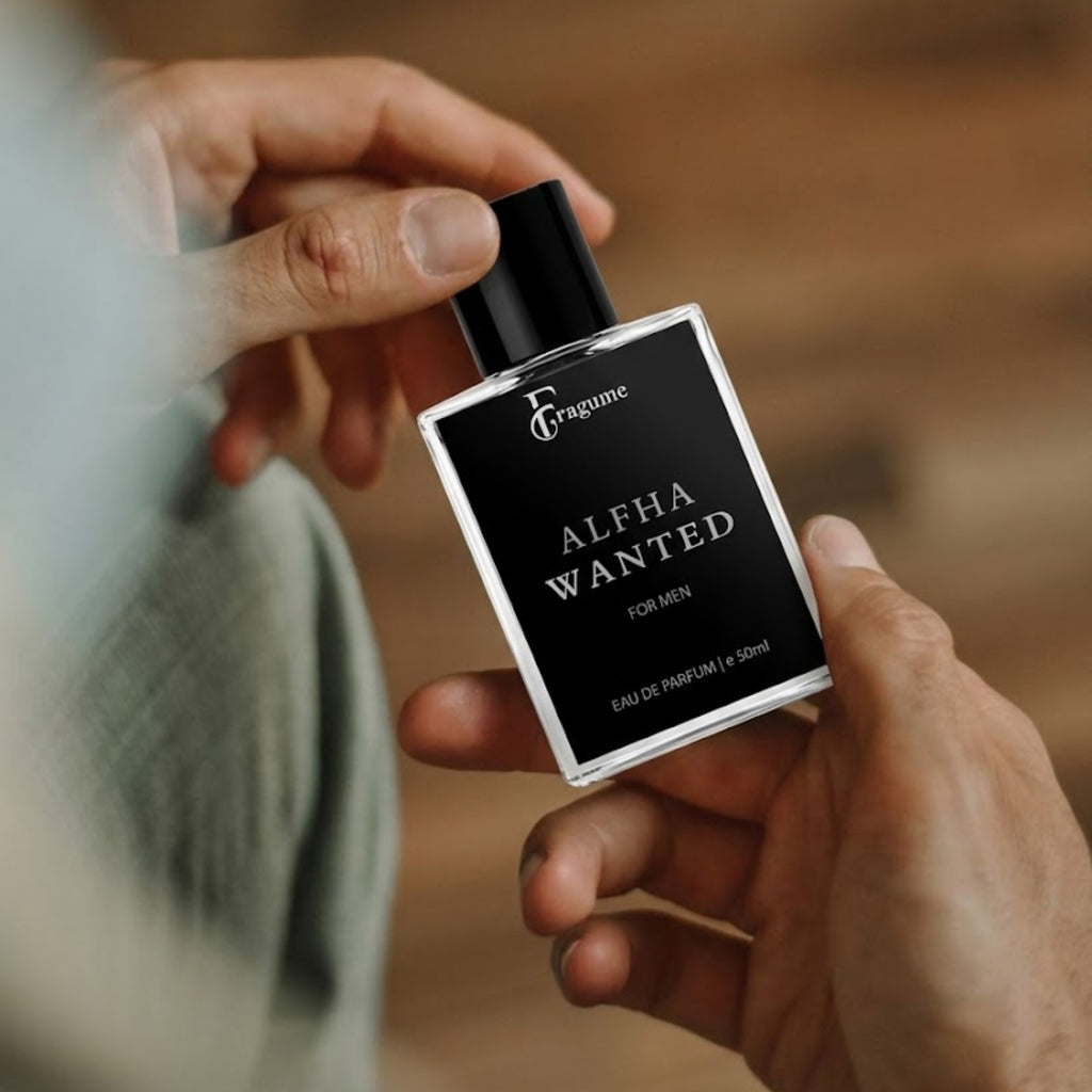 Person holding a perfume bottle labeled 'Alpha Wanted' by Fragume.