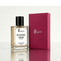 Fragume Iconic Her Eau De Parfum 50ml glass bottle with a textured magenta gift box on a reflective surface.